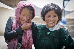 BAMYAN PROVINCE, Afghanistan - Two local girls enjoy the Arzu Studio Hope garden and playground in Dragon Valley, west of the town of Bamyan, June 20, 2012. Women enrolled the Arzu program receive higher-than average compensation for their work as rug weavers, and are required to attend literacy classes. They also have access to day care for their children, hot water to wash clothes, a kitchen, and a garden where they can grow their own vegetables and herbs. Younger children attend classes before and after weaving the rugs. (U.S. Army photo by Sgt. Ken Scar, 7th Mobile Public Affairs Detachment)