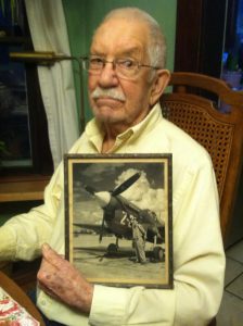 Howard Riggs holding a photo of him with a P-40. Courtesy photo.